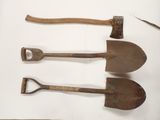 trois vieux outils sont posés sur une surface blanche