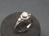 a close up of a diamond ring sitting on a rock