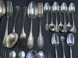 a lot of silver spoons and spoons on the table