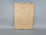an old book sitting on top of a table next to a gray wall