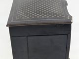 an old black wooden box with a black and white pattern on it