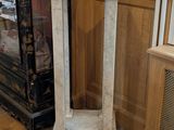 a marble pedestal in the corner of a room