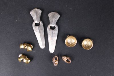 quelques objets en or et en argent sont posés sur une surface noire