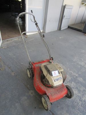 a red lawn mower that is sitting in the garage
