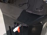 a large black box with a wooden handle on the floor