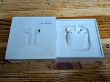 an apple airpods are sitting in a box on a wooden table