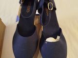 pair of navy blue shoes with gold buckles sitting on top of a box