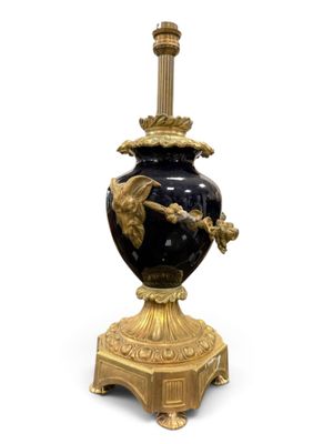 a black and gold vase with a bird on it