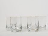 four shot glasses are lined up in a row on a white surface