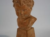 sculpture représentant le buste d'un jeune garçon sur un socle