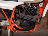 an orange and white motorcycle parked in a garage
