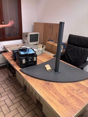 un homme debout devant un bureau sur lequel se trouve un ordinateur