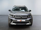 the front view of a silver suv parked in a showroom