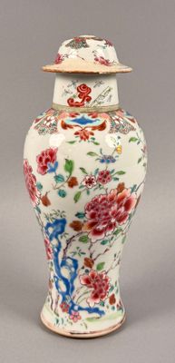 a vase with a lid that has flowers on it
