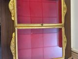 une vitrine rouge et dorée dans un coin de la pièce
