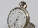 a silver pocket watch sitting on top of a coin
