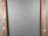 an old picture frame sitting on top of a table next to a chair