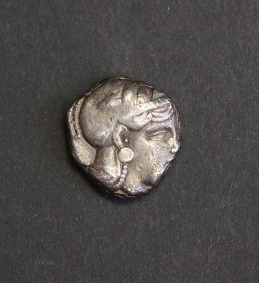 une pièce d'argent sur laquelle figure une femme assise sur une surface noire