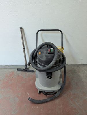a vacuum that is sitting on the floor next to a broom
