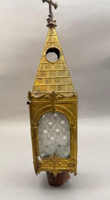 une tour horloge dorée surmontée d'une croix