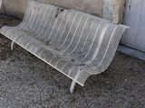 a metal bench that is sitting in front of a building