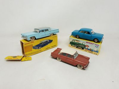 three toy cars are sitting on top of boxes on a white surface