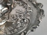 a silver plate with a bird on it on a table