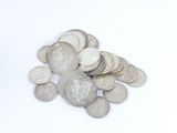 une pile de pièces d'argent posée sur une surface blanche