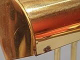 a close up of a gold metal object on a stand
