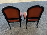 pair of black and orange chairs in the middle of a parking lot