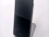 a black cell phone sitting on top of a stand