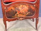 a red cabinet with a painting on it