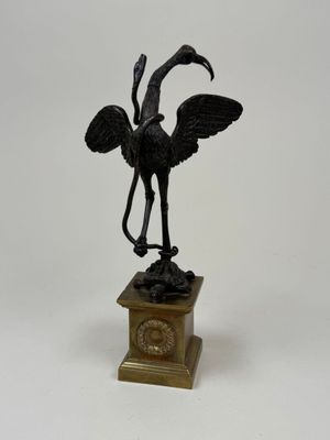 statue of a bird on a pedestal on a white background
