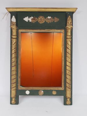 une image représentant un miroir vert et doré accroché à un mur blanc