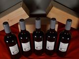 six bottles of red wine in a wooden box on a red cloth