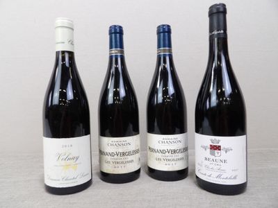 quatre bouteilles de vin sont alignées sur une table