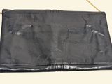 black leather purse with gold chain strap on white background