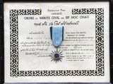 certificat encadré, orné d'un ruban bleu et d'une étoile, dans un cadre noir et blanc