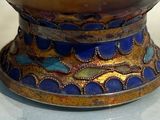 a close up of a vase on display on a table