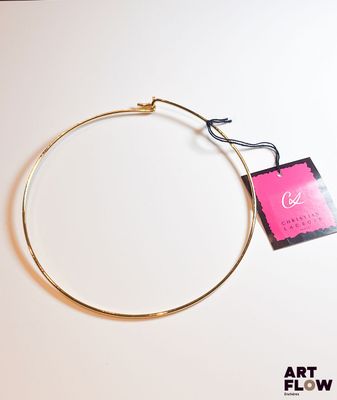 une photo d'un bracelet en or sur lequel est accrochée une étiquette rose