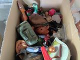 une boîte en carton remplie de jouets divers, posée par terre