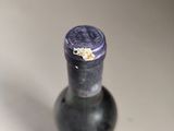 a bottle of wine that has a purple cap on it