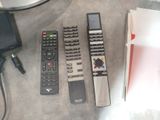 four remote controls sitting on a table next to a laptop