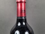 a bottle of red wine with black and white designs on it