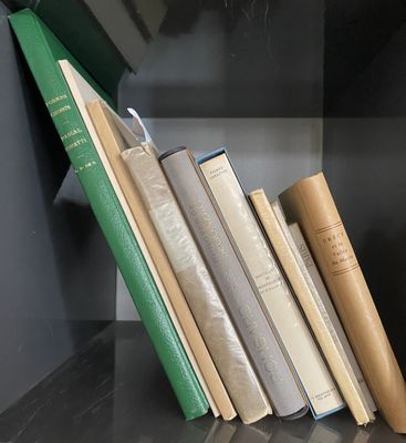 several books are stacked on a shelf in a book case