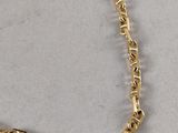 a close up of a gold chain on a white surface
