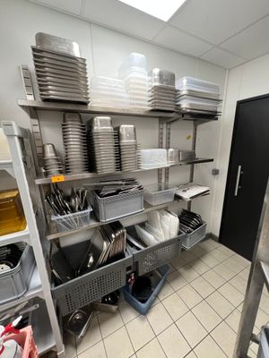 une cuisine où les étagères sont remplies de vaisselle et de casseroles