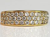a close up of a gold and diamond ring on a white surface