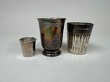 three silver cups sitting next to each other on a table