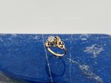 une image représentant une bague en or sertie de diamants, posée sur une pierre bleue